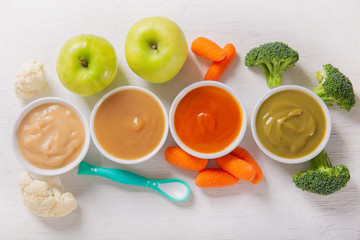 Baby food. Various kinds of bowls of fruit and vegetable puree with ingredients for cooking, top view