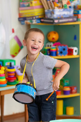 Little boy plays a toy drum. Talented boy future musician