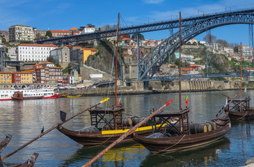 Traditional boats on Douro river with bridge in Porto, Portugal