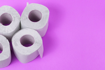 Toilet paper close-up. White paper for household and rubbing the anus from feces. Toiletries on purple background