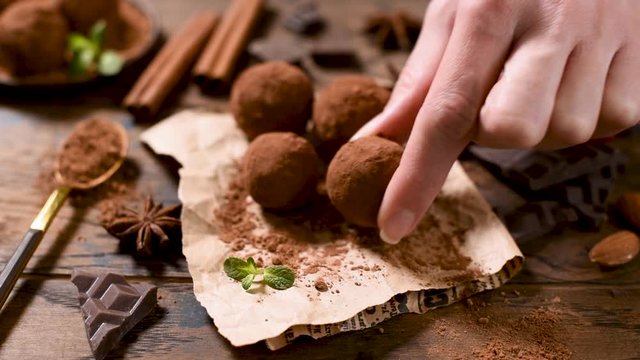 Homemade chocolate truffles on parchment paper coated in raw cocoa powder. Vegan, vegetarian dark chocolate truffles, chocolate cocoa balls with spices