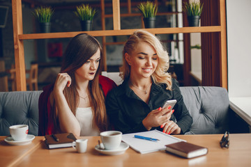 Pretty businesswomen working. Cute girls sitting at the caffee