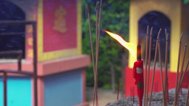 Close up burning red candle Incense sticks and smoke from incense burning
