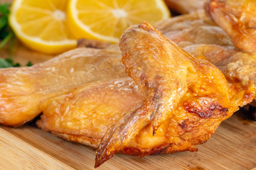 fried chicken on a wooden bord with lemon.