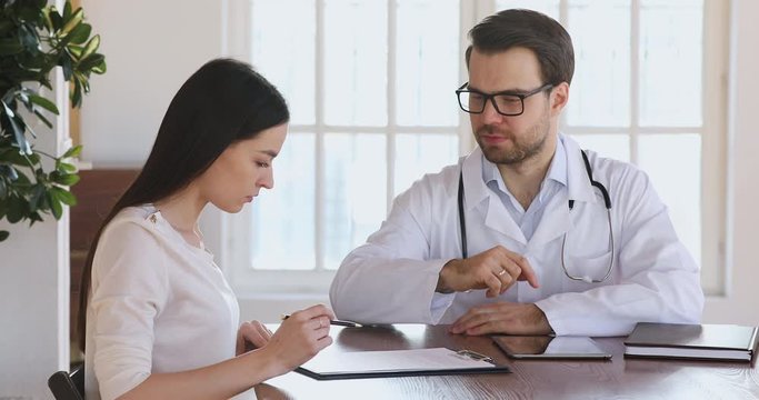 Female patient sign medical form insurance agreement handshake male doctor