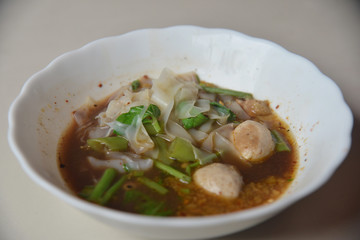 Thai Noodle With Stewed Soup (Kuay Tiew Ruer) served with Pork Ball and Pork. This is one of popular street food menu in Thailand. 
