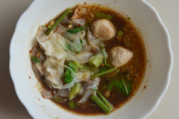 Thai Noodle With Stewed Soup (Kuay Tiew Ruer) served with Pork Ball and Pork. This is one of popular street food menu in Thailand. 