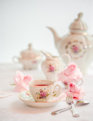 Tea time served with  fine china porcelain set with floral pattern. 