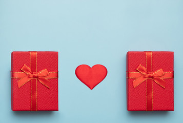 Romantic concept for Valentine`s Day. Flat lay. red heart with red and white gift boxes on a blue background. Romantic concept. Copy Space