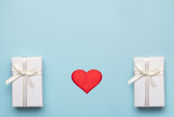 Romantic concept for Valentine`s Day. Flat lay. red heart with white gift boxes on a blue background. Romantic concept. Copy Space