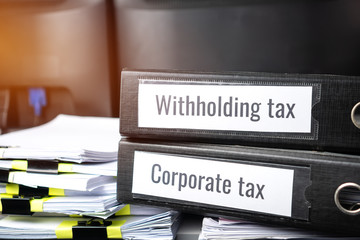 Stack of taxes binders report concept: Document of Withholding tax and corporate tax for accountant. withholding tax sometimes applies to royalties, rent or even sale duty must be paid to government