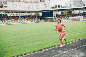 Sports girl at the stadium. Beautiful girl doing sports.The girl is running