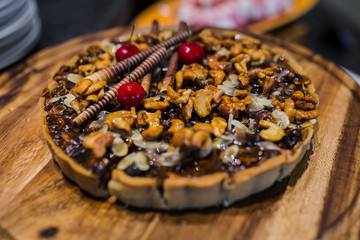 Cashew nut and caramel syrup on chocolate tart cake