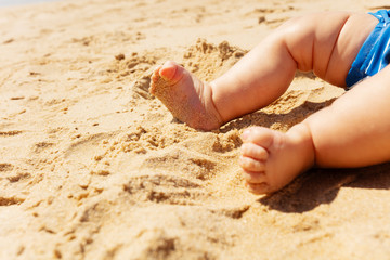 Close-up of baby infant toes feet on the sea beach