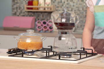 Glass teapot and cookware on wooden counter of open plan kitchen