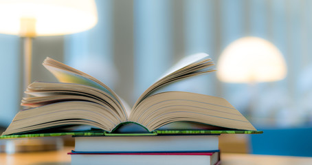 Open book lying on the table in the library