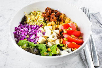 Vegetarian buddha bowl. Raw vegetables, tofu and bulgur in white bowl. Vegetarian, healthy, detox food concept, close-up