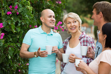 males and females drinking coffee outdoors