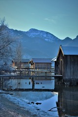 Idyllic sunny winter day at the bavarian Lake Kochelsee (Lake Kochel) at Kochel am See. View to the beautiful wooden boathuts
