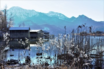 Idyllic sunny winter day at the bavarian Lake Kochelsee (Lake Kochel) at Kochel am See. View to the beautiful wooden boathuts