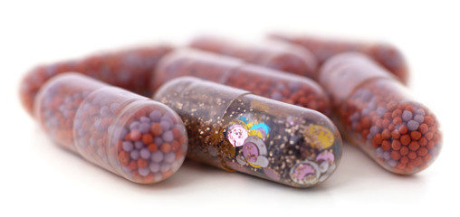 Sequins in a capsule together with other capsules.