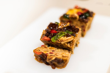 Freshly baked fruit cake filled with dried fruits, divided into slices, ready to eat.
