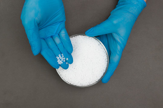 Plastic granules . Polypropylene, polyethylene pellets in hands with gloves. Quality control of plastic in the laboratory in production