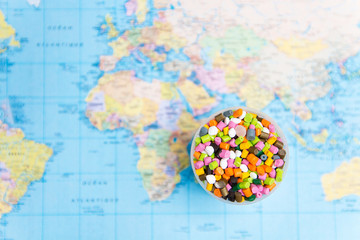 Plastic pellets on the background of the world map .The concept of Plastic pollution. The concept of world environment day.Selective focus