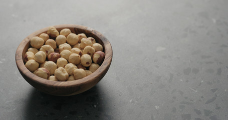 roasted hazelnuts in olive bowl on terrazzo countertop