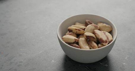 brazil nuts in white bowl on terrazzo countertop