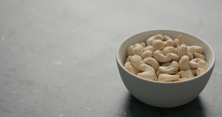 cashew nuts in white bowl on terrazzo countertop