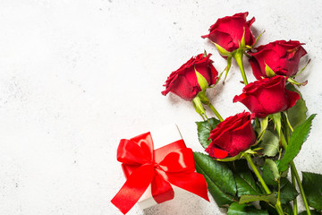 Red roses flower and present box on white background top view.