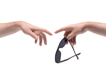 Two male hands passing one another a sunglasses on white background