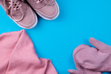 pink sneakers pink jacket and pink gloves on a blue background