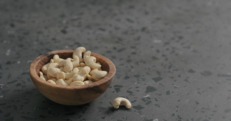cashew nuts in olive bowl on terrazzo countertop