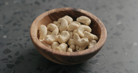 cashew nuts in olive bowl on terrazzo countertop