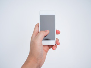 Hand holding smartphone with white wall background
