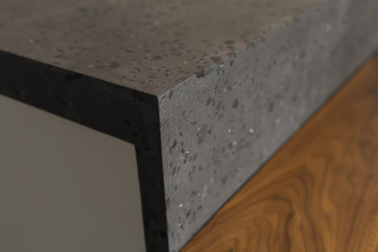 Closeup shot of adjoining between walnut table and concrete countertop