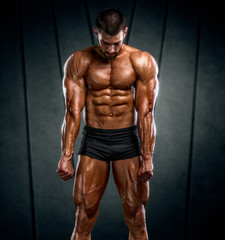 Fototapeta na wymiar Bodybuilder Posing and Flexing Muscles. Studio Shot