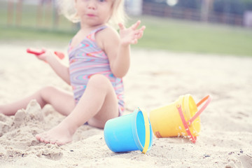 Cute little girl playing on the beach. Summer vacation concept.