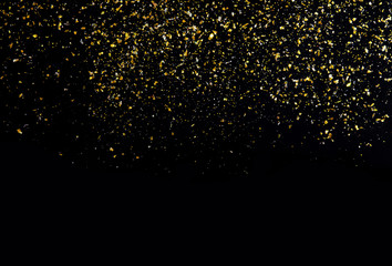 Golden glitter texture on black abstract background