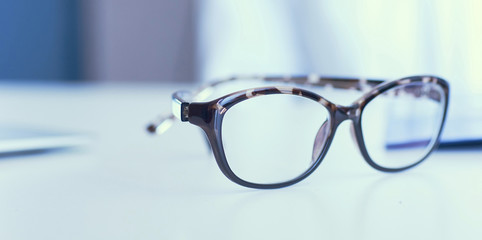 Closeup of white desktop with spectacles on it.