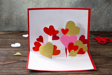 Valentine's Day greeting card or birthday present on wooden table. Children's art project crafts...