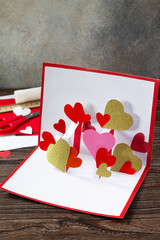 Valentine's Day greeting card or birthday present on wooden table. Children's art project crafts...