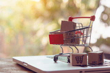 Shopping online concept - Parcel or Paper cartons with a shopping cart logo in a trolley on a...