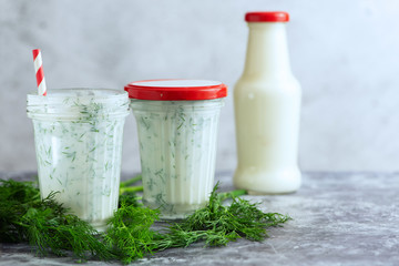 Kefir drink on the gray background with dill