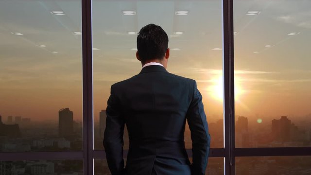 Business people watch the city at sunset.