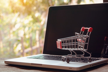Shopping online concept - Empty shopping cart or trolley on a laptop keyboard. Shopping service on...