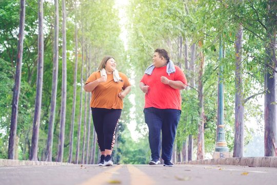 Fat Asian couple chatting happily while jogging