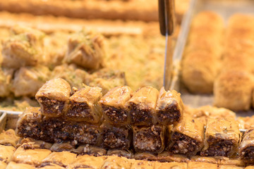Baklava (modern Middle Eastern Arab-style dessert) baked with sugar and honey syrup, sweet and stuffed with almonds, nuts, chocolate or pistachios. In the old market, Jerusalem.